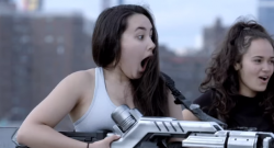 Passantin hält Optikor-Waffe und guckt erstaunt