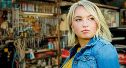 Junge Frau vor Autowerkstatt